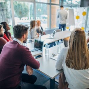 Group of people sitting at a business presentation/conference.